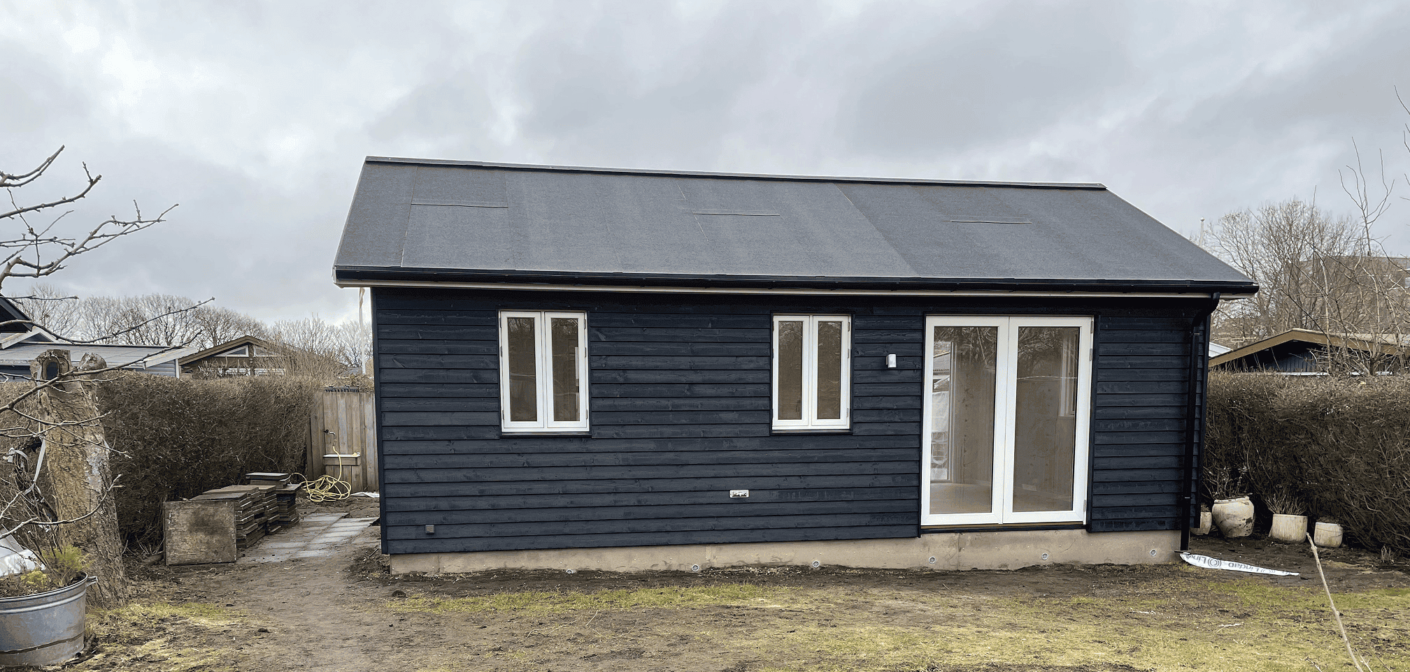 nybygget kolonihavehus med store vinduespartier