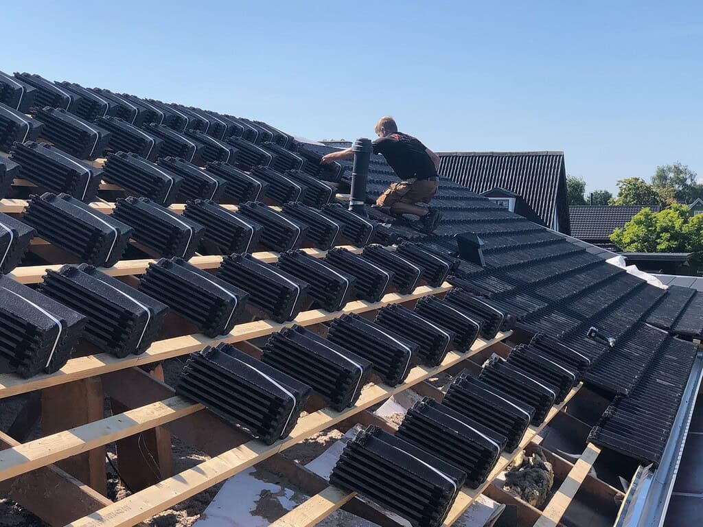 tømrer lægger tegl på tagryg