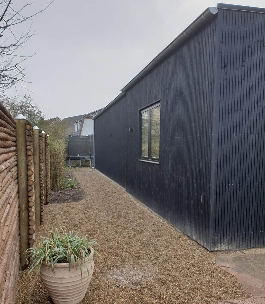 tilbygning i i sortmalet træ set fra siden